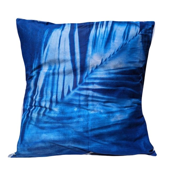 Blue palm leaf patterned pillow on a white background