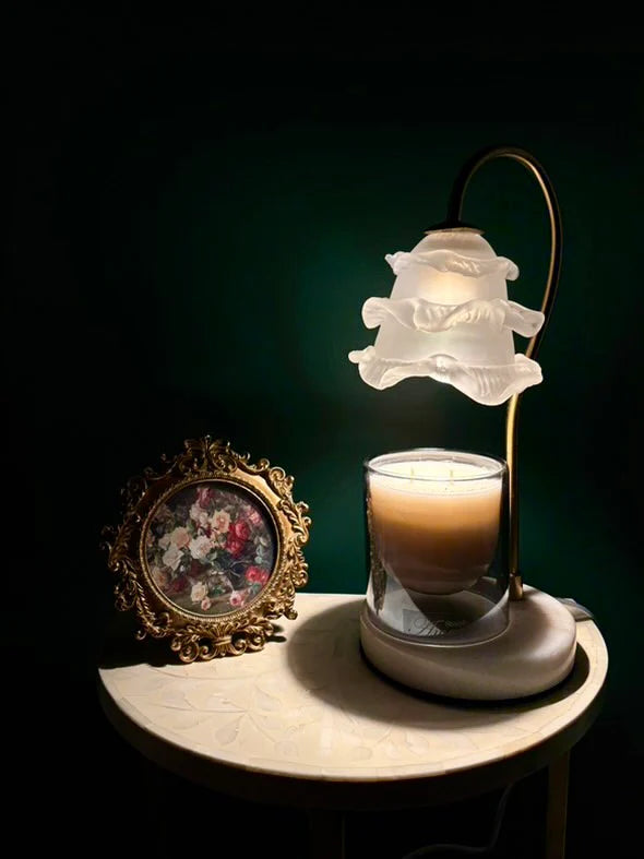 Candle in a glass holder with a decorative lamp on a dark background