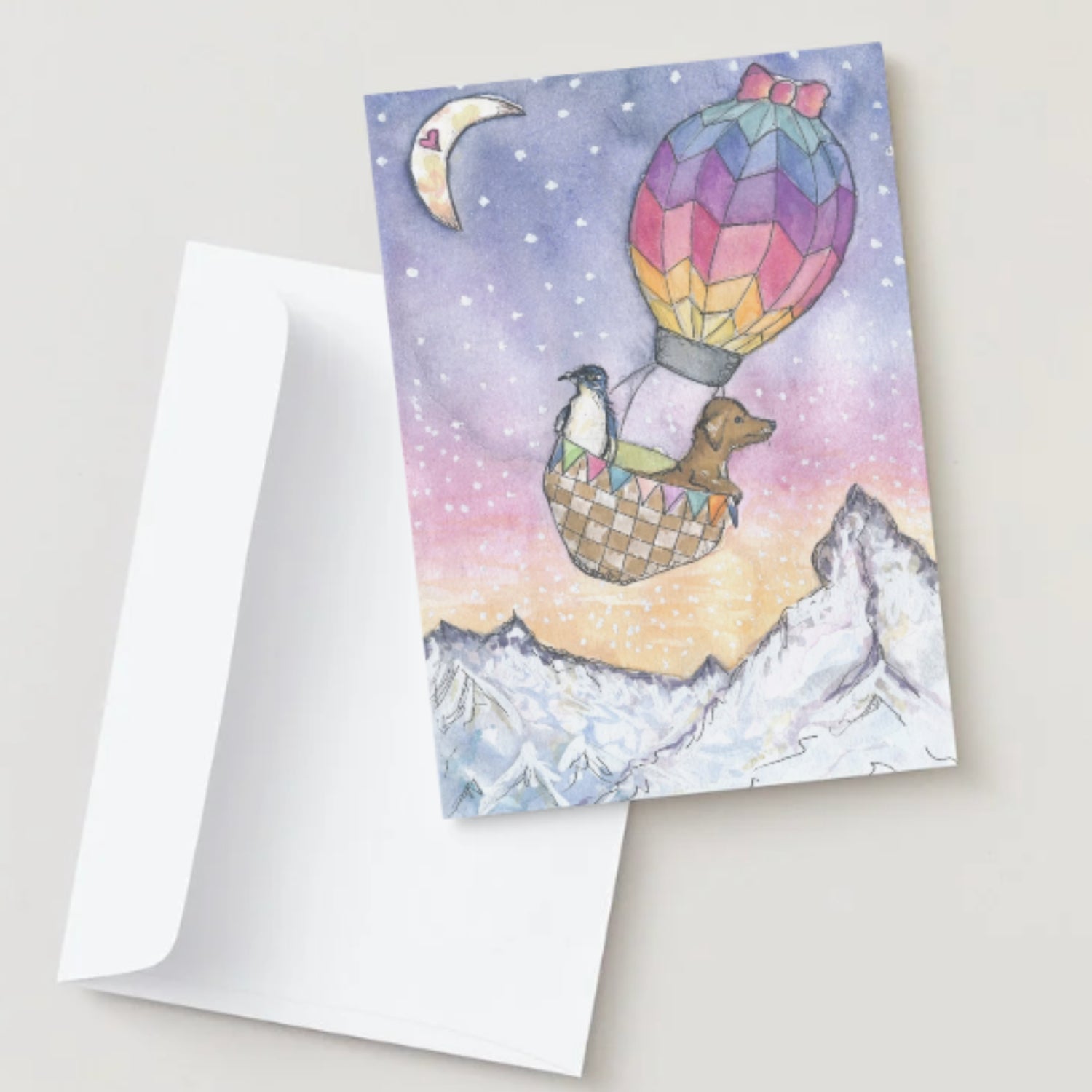 Greeting card with a colorful hot air balloon and mountain scene, featuring a penguin and dog.