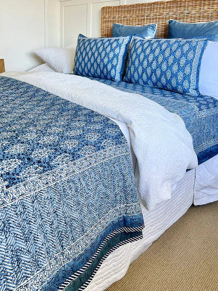 Bed with blue and white patterned bedding and pillows.