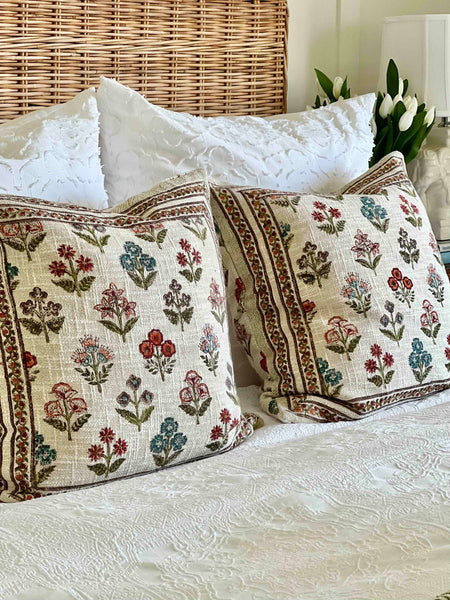 Decorative pillows with floral patterns on a bed