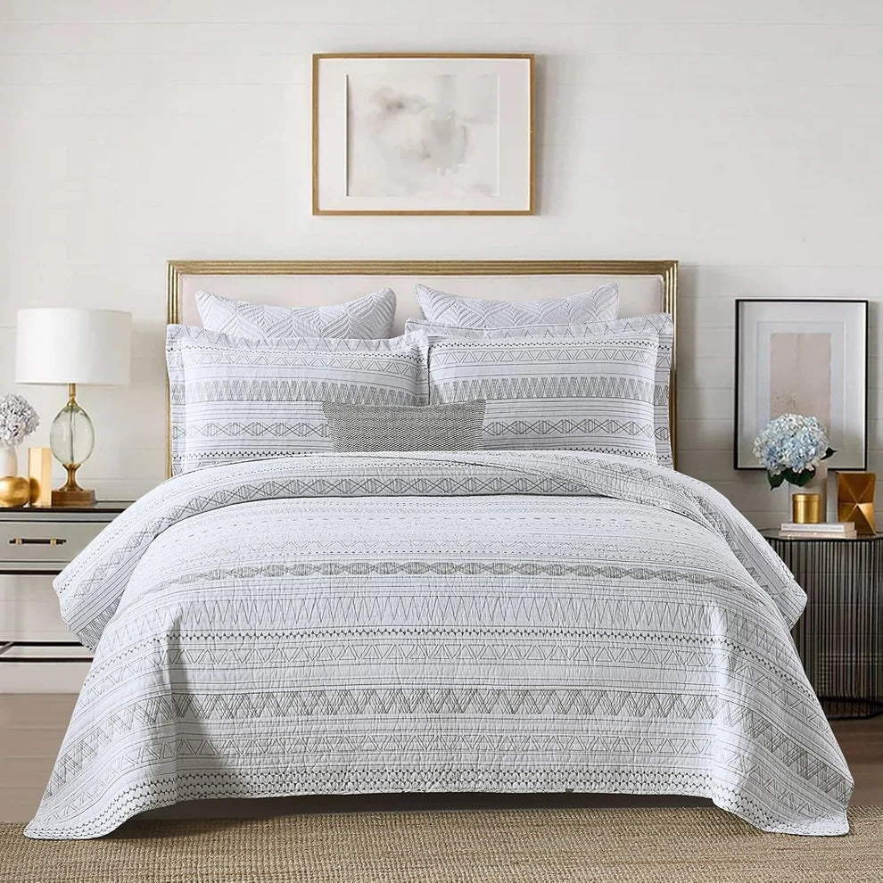 Bedroom with a neatly made bed featuring a patterned comforter and pillows.