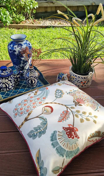 Decorative pillow with floral pattern on a wooden surface outdoors