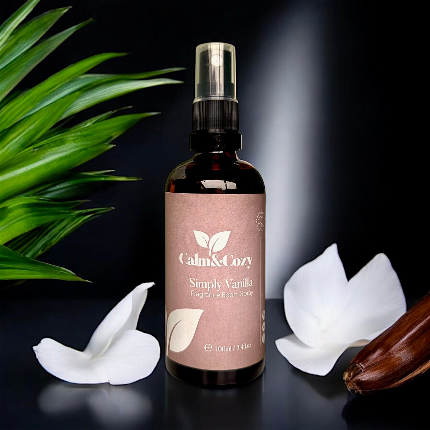 Bottle of Calm & Cozy Simply Vanilla fragrance body spray with floral elements on a dark background