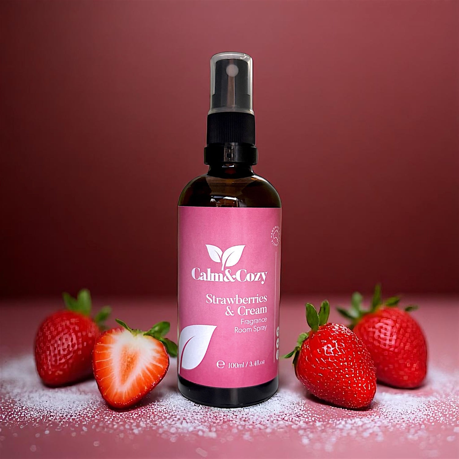 Bottle of 'Calm & Cozy' Strawberries & Cream fragrance with strawberries on a pink background