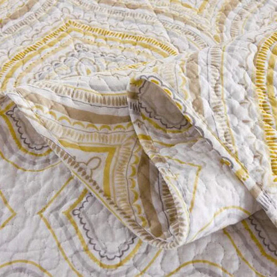 Close-up of a patterned fabric with yellow and gray design on a white background