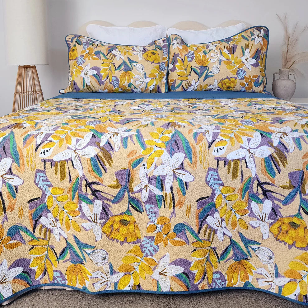 Floral and bird patterned bedspread on a bed with matching pillows.