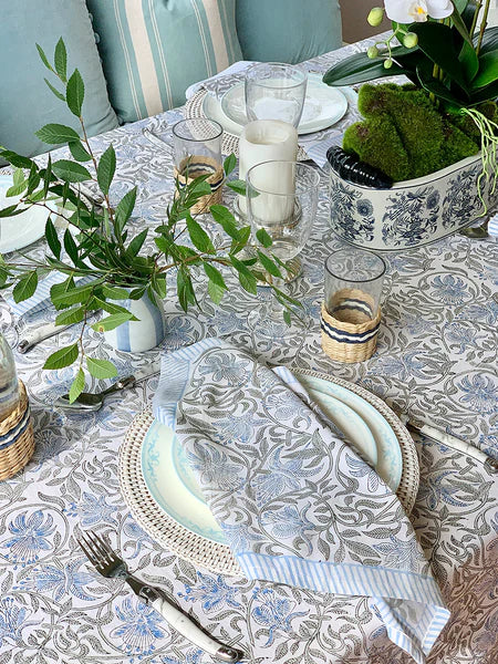 Elegant table setting with patterned tablecloth, plates, and glasses.