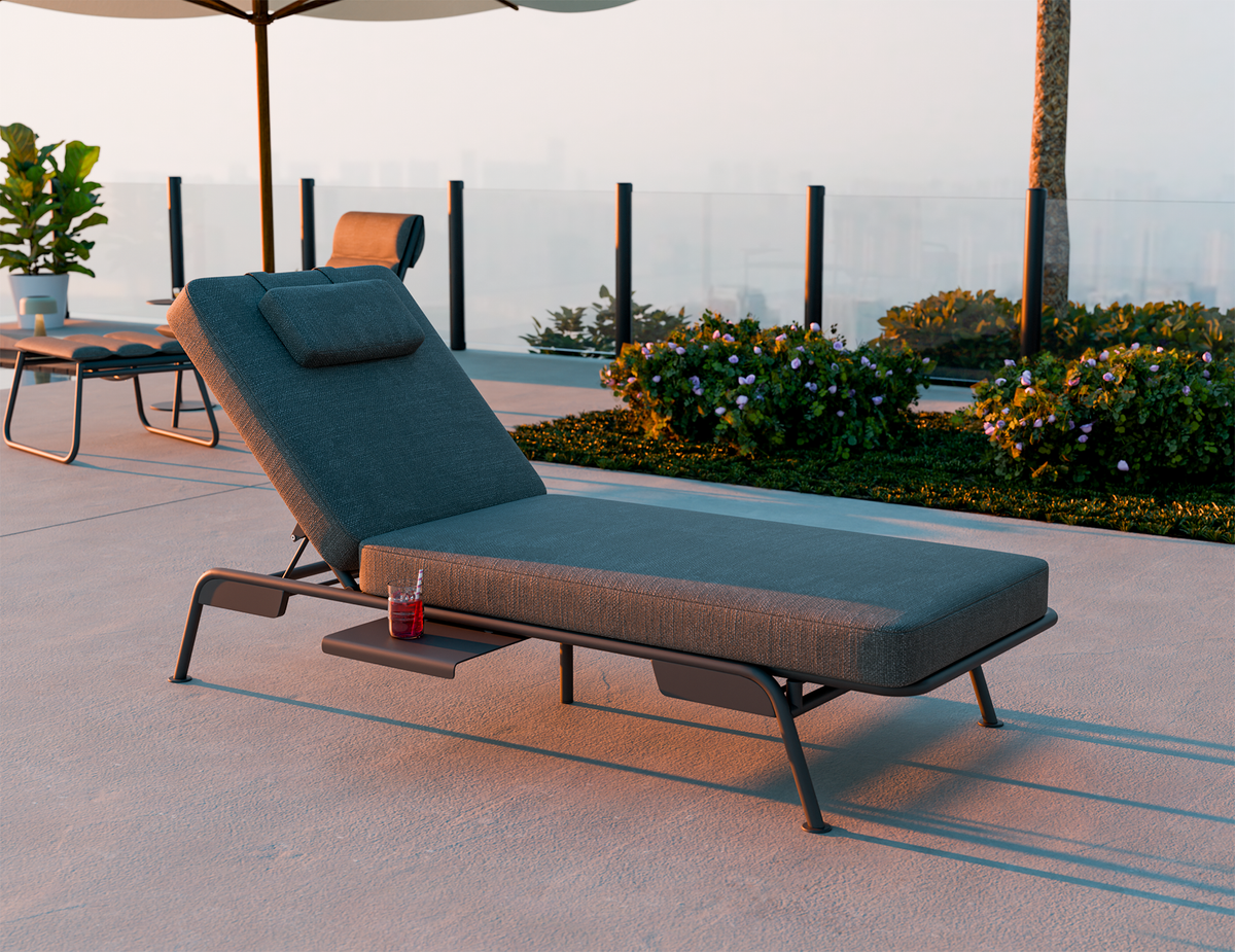 Outdoor lounge chair with blue cushion on a patio with plants and tables in the background