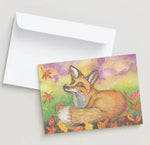 Greeting card with a fox illustration on a colorful background, accompanied by a white envelope.