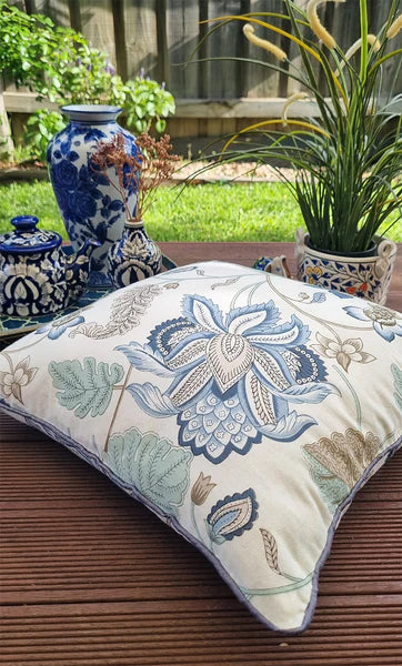 Decorative pillow with floral pattern on a wooden surface outdoors