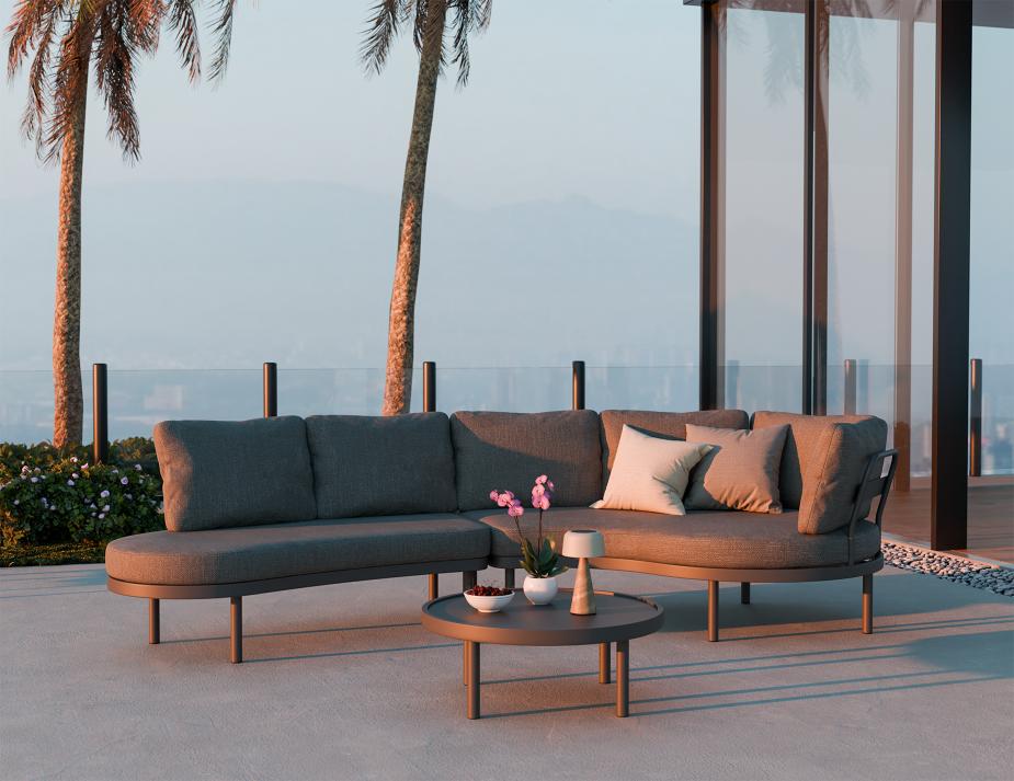 Outdoor patio set with a sectional sofa and coffee table on a patio with palm trees and ocean view.