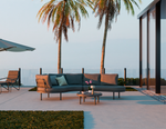 Outdoor patio with a sectional sofa, chairs, and a coffee table under palm trees.