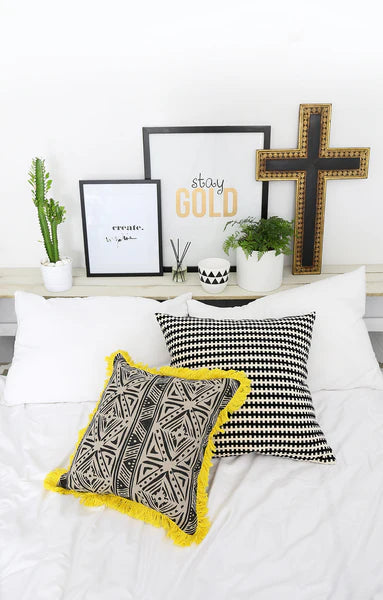 Decorative pillows on a bed with wall art in the background