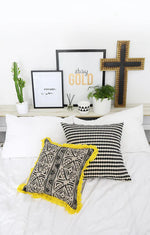 Decorative pillows on a bed with wall art in the background