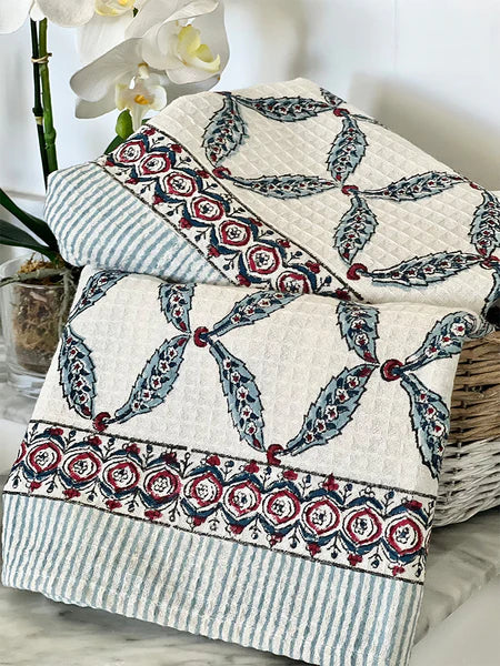 Quilt with intricate patterns and a pillow on a light background