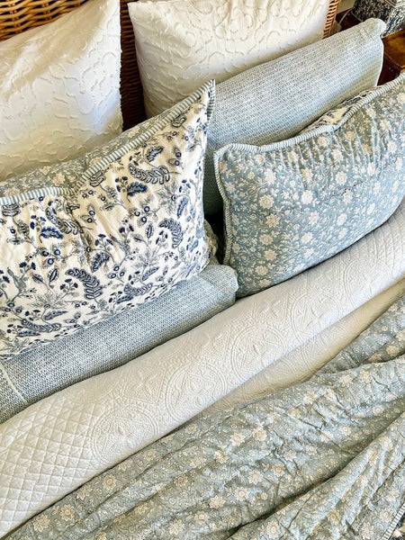 Collection of patterned pillows in neutral colors on a textured surface