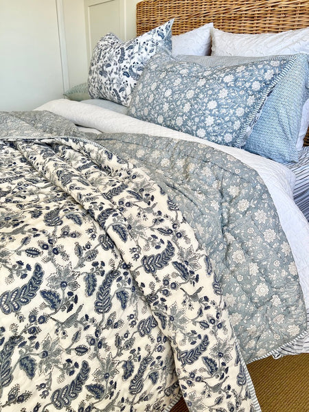Bed with floral and striped bedding in a bedroom setting