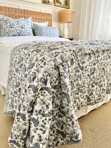 Bed with floral-patterned comforter in a bedroom setting