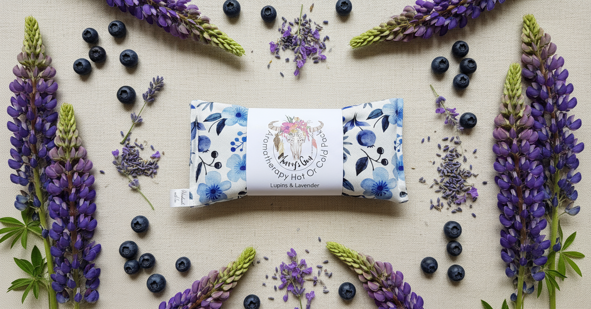 Heat pack with floral packaging surrounded by purple flowers and blueberries on a beige background