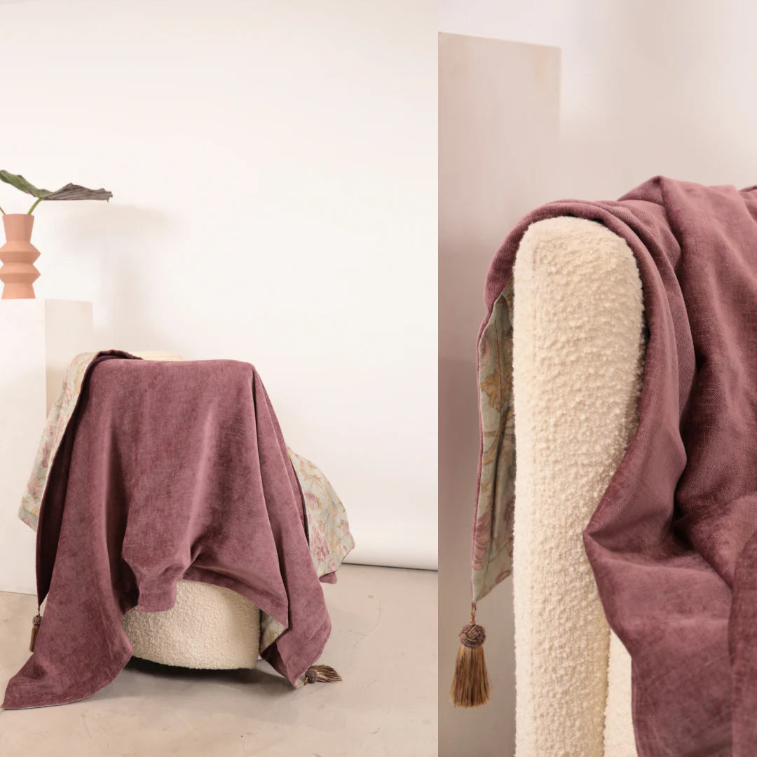 Mauve blanket draped over a chair with a neutral background