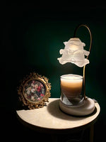 Candle in a glass holder with a decorative lamp on a dark background