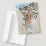 Card with a dog illustration on a beach scene, featuring a white envelope.