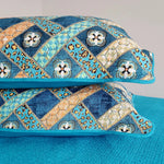 Decorative pillows with a blue and orange pattern on a gray background
