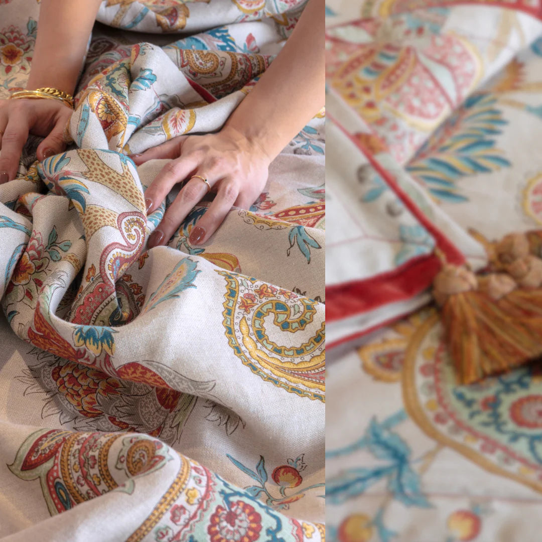 Close-up of hands holding patterned fabric with a decorative pillow in the background.