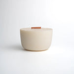 White ceramic bowl with a wooden base on a light gray background