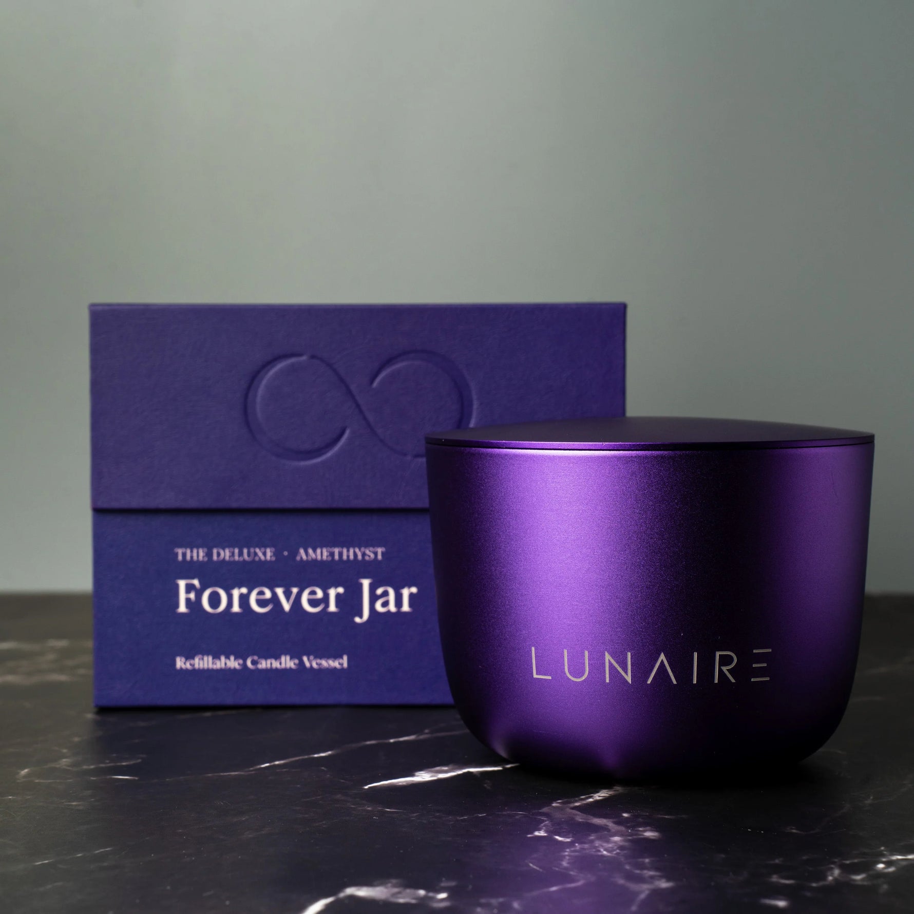 Purple candle vessel with box labeled 'Forever Jar' by LUNAIRE on a dark surface.