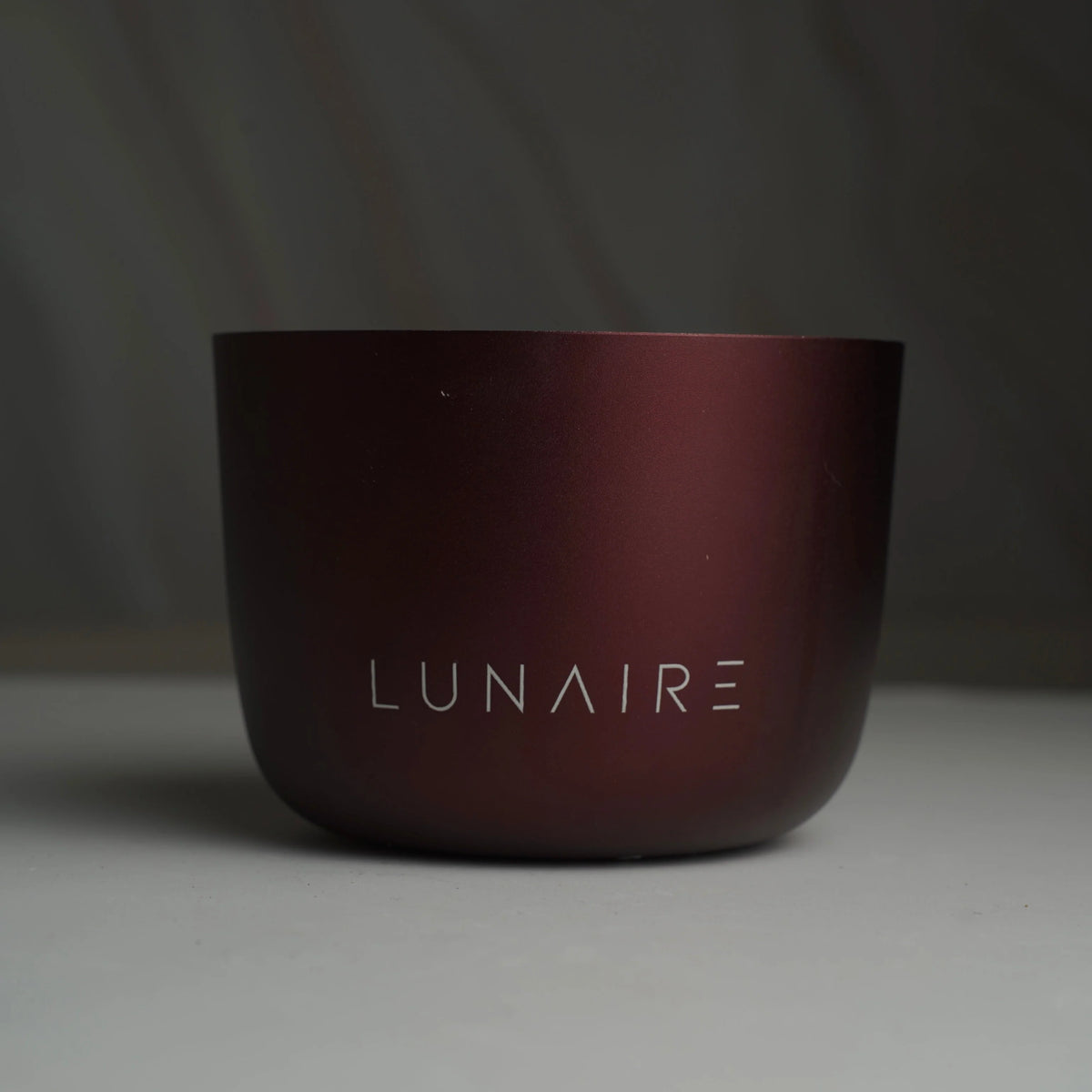 Dark red cup with 'LUNAIRE' branding on a gray background