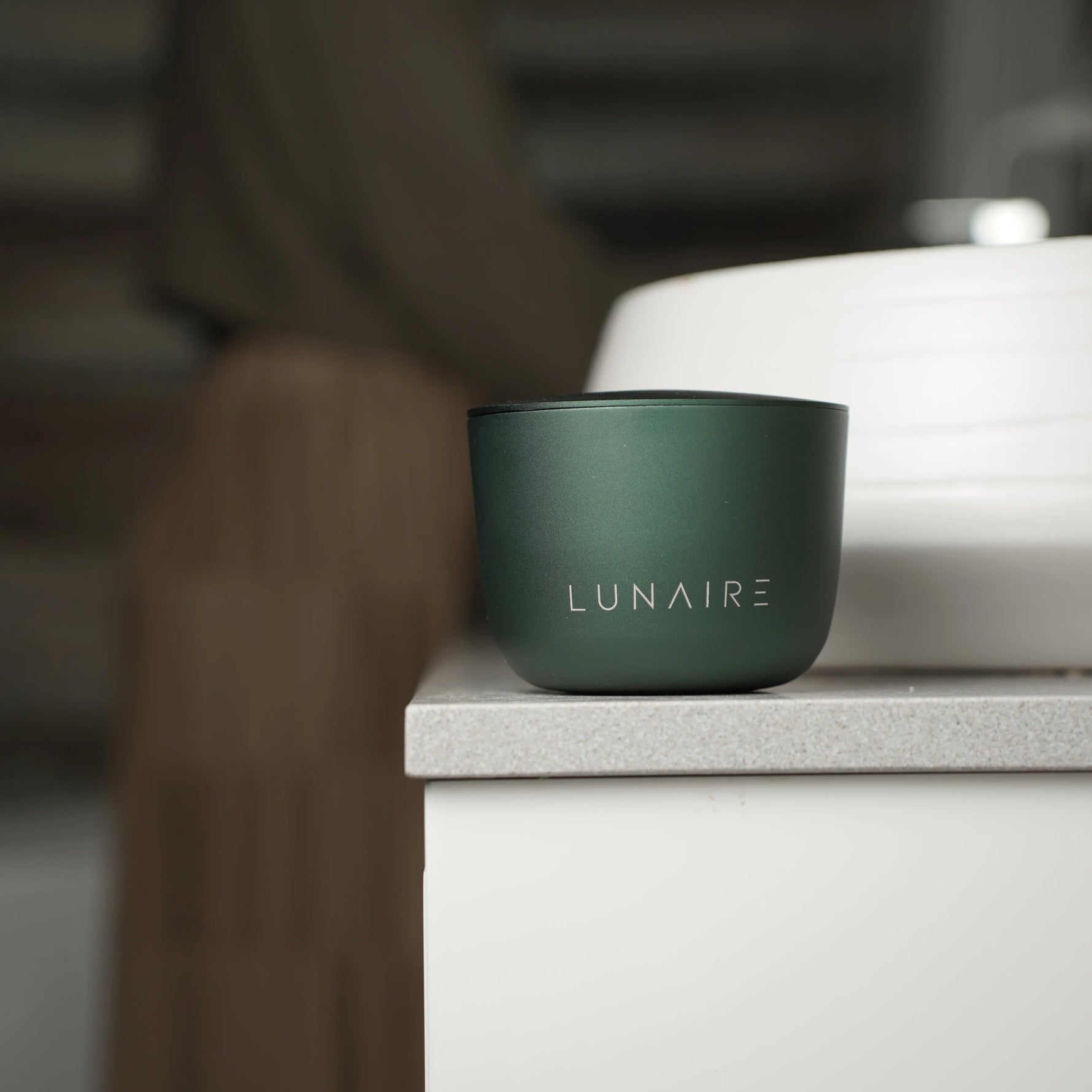 Green cup with 'LUNAIRE' branding on a blurred background