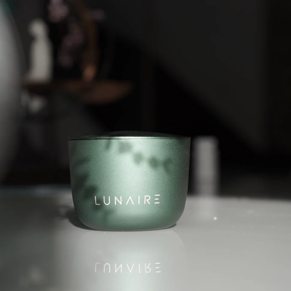 Green container with 'LUNAIRE' branding on a reflective surface with a blurred background