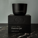 Black candle jar with 'LUNAIRE' branding on a matching black box with 'Forever Jar' text.