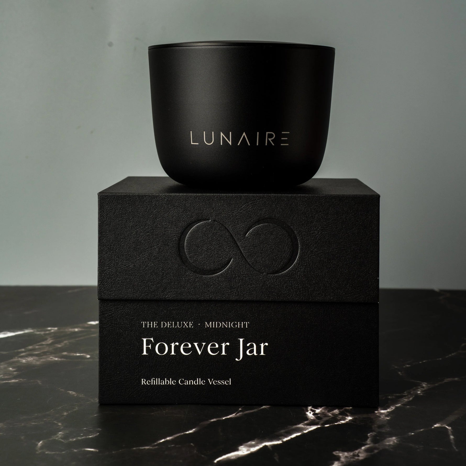 Black candle jar with 'LUNAIRE' branding on a matching black box with 'Forever Jar' text.