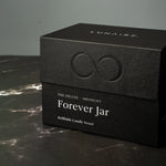 Black box with 'LUNAIRE' branding and 'Forever Jar' text on a dark surface.