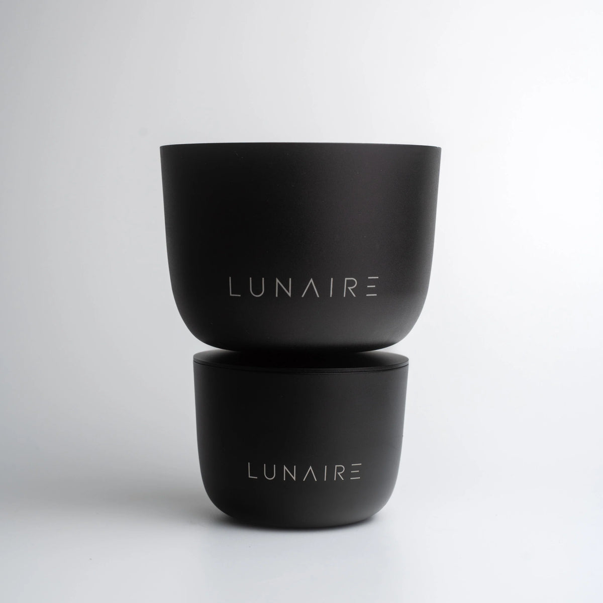 Two black containers with 'LUNAIRE' branding on a light gray background
