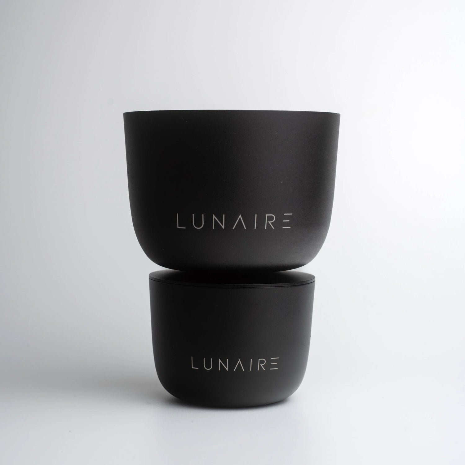 Two black containers with 'LUNAIRE' branding on a light gray background