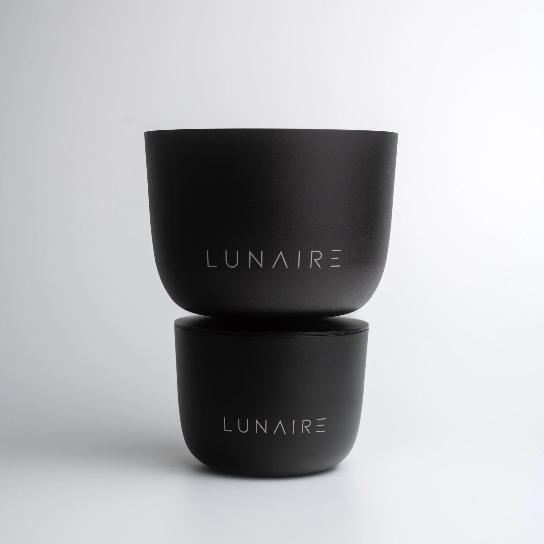 Two black containers with 'LUNAIRE' branding on a light gray background