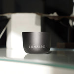 Black container with 'LUNAIRE' branding on a reflective surface