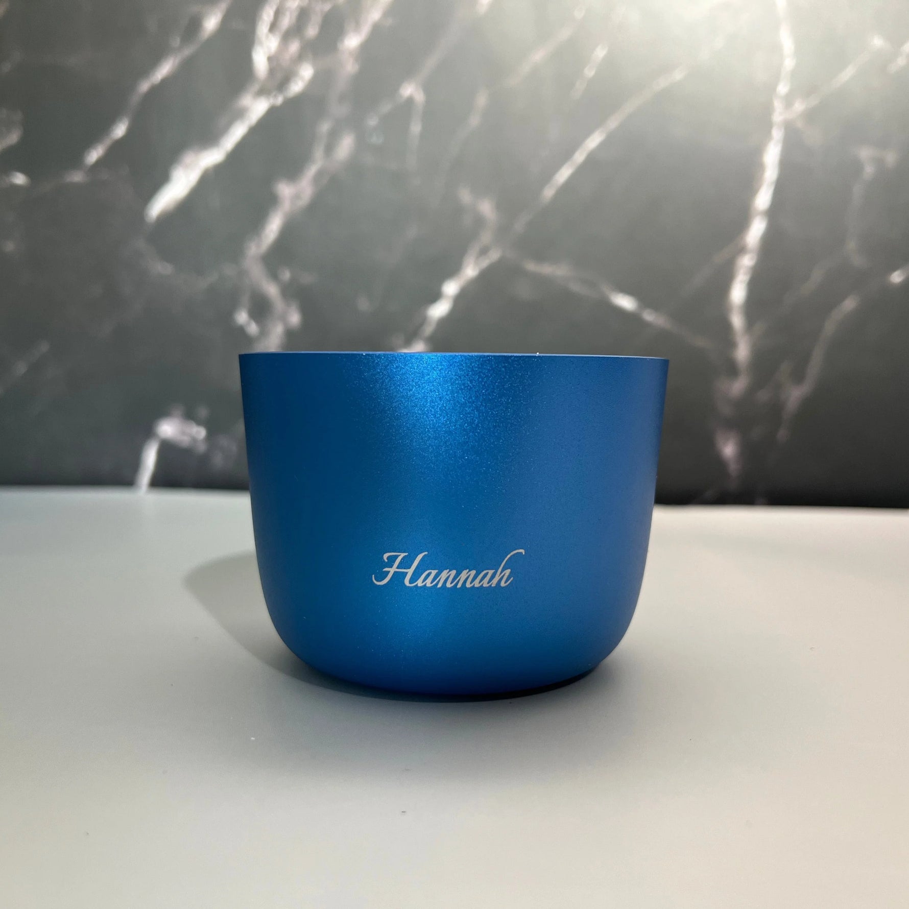 Blue cup with 'Hannah' engraving on a marble background