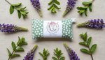 Heat pack packaging with a label surrounded by lavender flowers and leaves on a light background