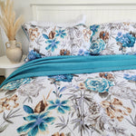 Floral bedding set with blue and brown flowers on a bed in a bedroom setting.