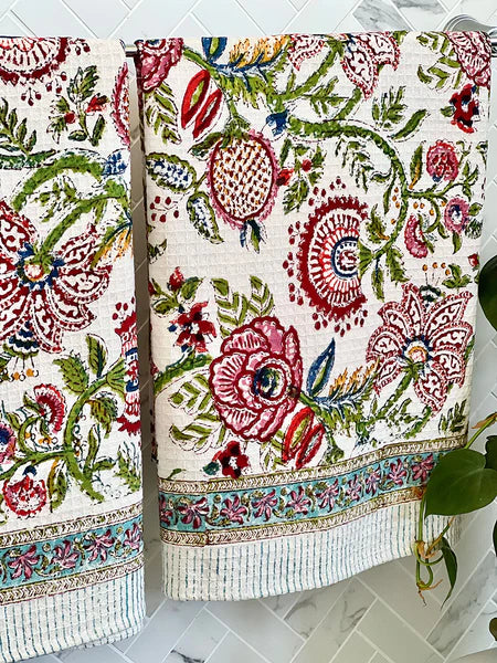 Two floral-patterned towels on a marble surface