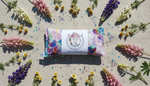 Colourful  heat pack surrounded by flowers on a textured surface