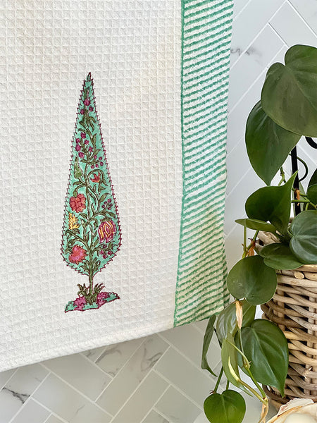 Decorative towel with floral design on a tiled bathroom wall
