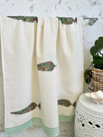 White shower curtain with floral patterns on a bathroom wall.