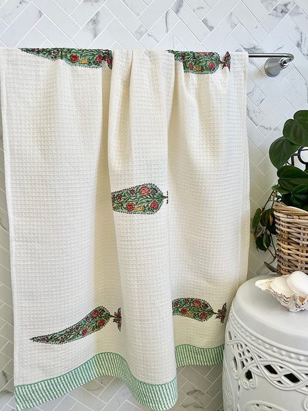 White shower curtain with floral patterns on a bathroom wall.