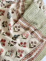 Textile with floral patterns and green stripes on a white background